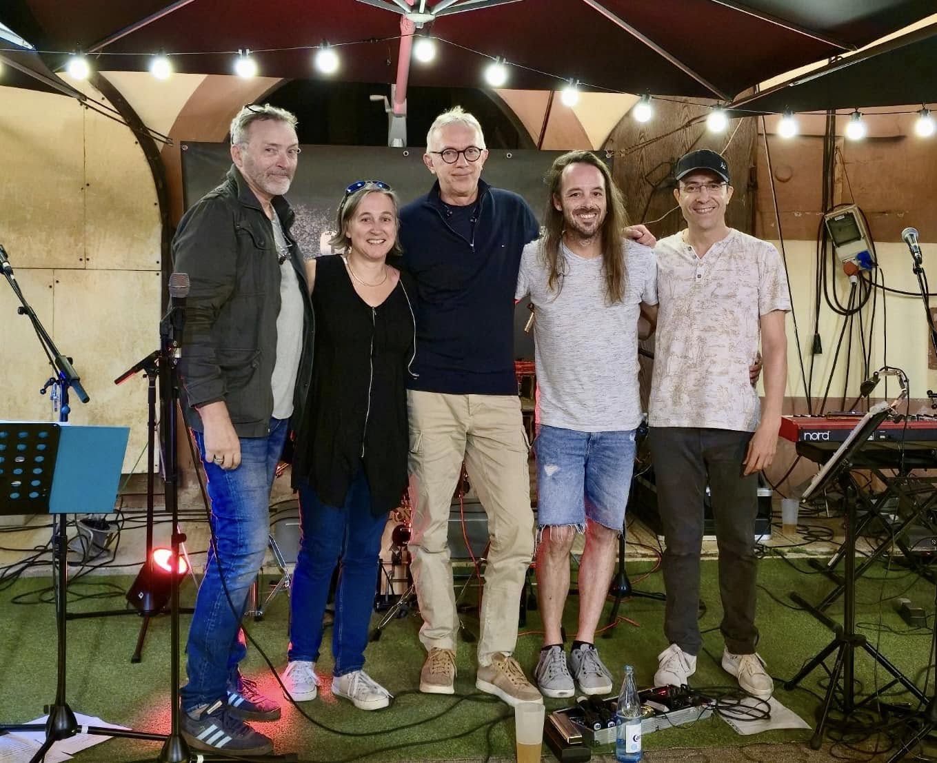 Les cinq membres d'Eden Seedz posent ensemble sous les guirlandes lumineuses après un concert